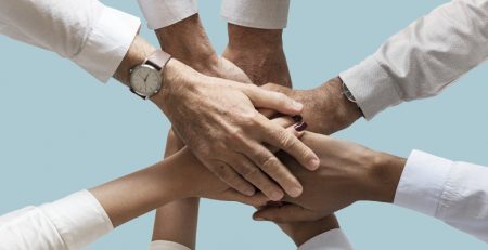 Afbeelding met handen op elkaar voor de blog dag van de vrijwilliger