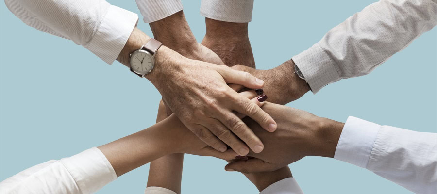 Afbeelding met handen op elkaar voor de blog dag van de vrijwilliger