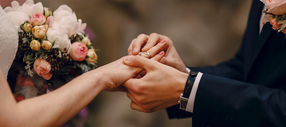 Groom putting ring on bride's finger huwelijksbedankjes