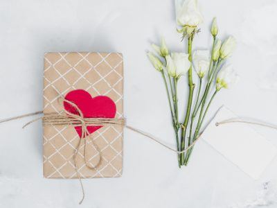Cadeautje met een hartje erop met witte bloemen ernaast