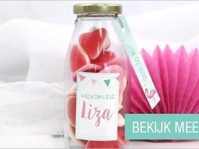 Melkfles gevuld met hartjes en een persoonlijk label kraambedankjes