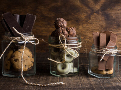 Chocolade bedankjes en dag van de chocolade Drie glazen potten met verschillende lekkernijen.