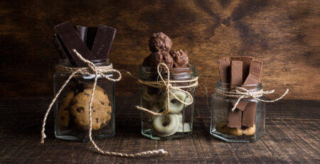 Chocolade bedankjes en dag van de chocolade Drie glazen potten met verschillende lekkernijen.