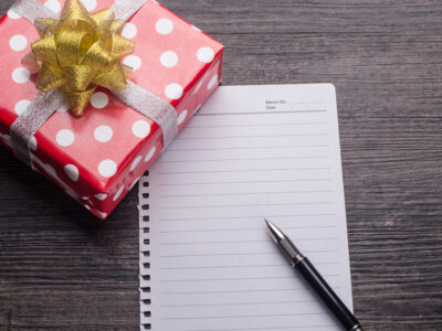 Een rood cadeau met pen en papier ingezet als een cadeau voor een collega cadeautip collega