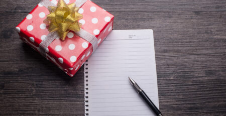 Een rood cadeau met pen en papier ingezet als een cadeau voor een collega cadeautip collega