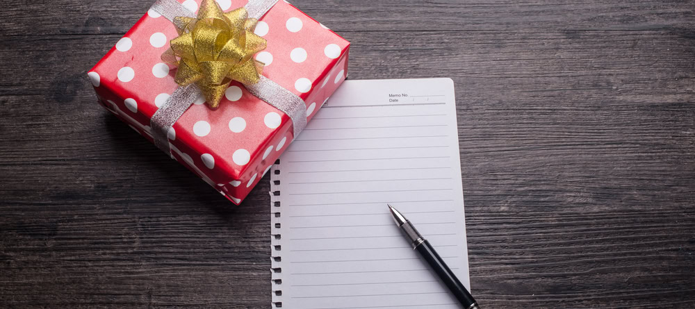 Een rood cadeau met pen en papier ingezet als een cadeau voor een collega cadeautip collega